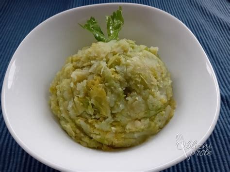 Fotografija ocvrtega brstičnega ohrovta v zlatkasto rjavem testu, postreženega na krožniku.