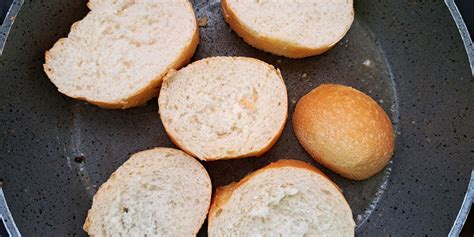 Sestavljena jed: popečen kruh s paradižnikovo kašo, brstičnim ohrovtom in poširanim jajcem na vrhu.