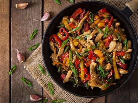 Priprava stir-fry jedi z mesom, zelenjavo in kitajskim zeljem v voku.