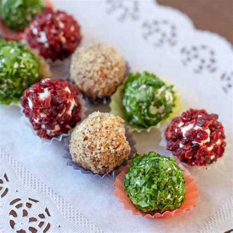 Raznobojne kuglice od sira i oraha, servirane na elegantnom tanjiru.