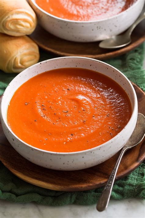 Thematic photo of a bowl of delicious tomato soup with fresh basil