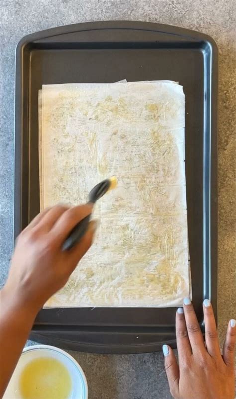 Infographic showing the process of layering phyllo dough in a pan, brushing each layer with oil.