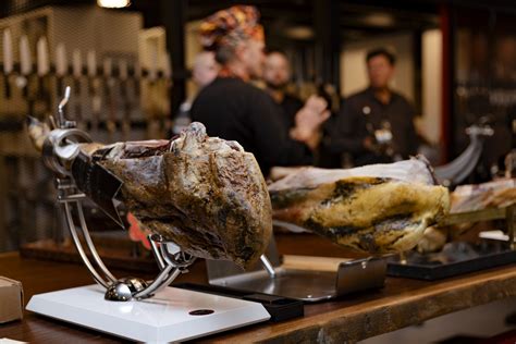 Prikaz pravilnega rezanja pršuta z nožem na stojalu.