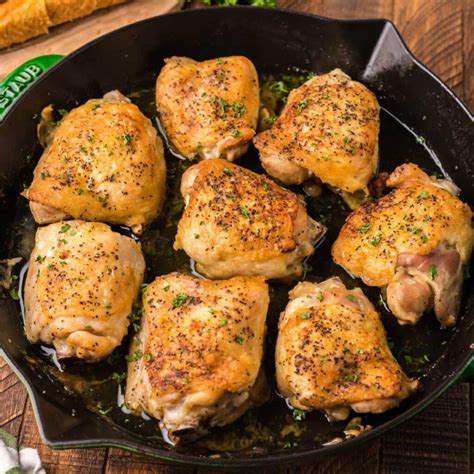 Photo of golden-brown pan-seared chicken thighs in a cast iron skillet.
