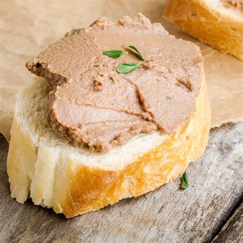 Thematic photo of a homemade chicken pâté spread on toast with fresh herbs