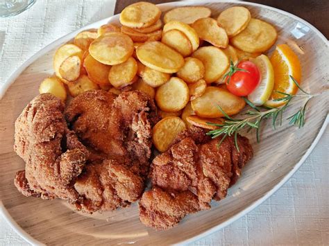 Serviranje ocvrtega piščanca z različnimi prilogami