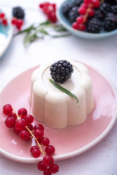 Fotografija panna cotte, obrnjene iz modelčka na krožnik z okrasnim prelivom