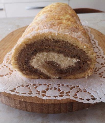 Ilustracija prikazuje postopek mazanja kreme na biskvit in zvijanja rolade.
