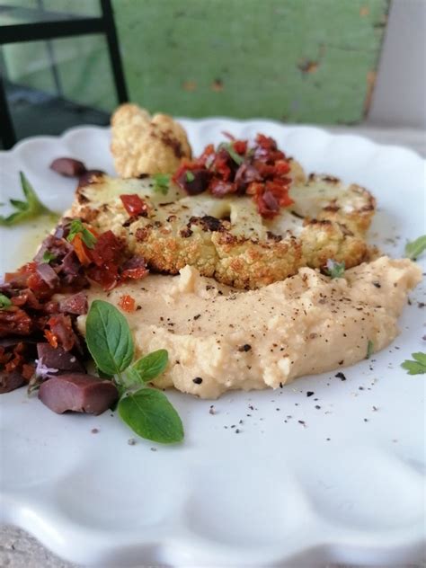 Kremast hummus s suhimi paradižniki, postrežen na kruhkih