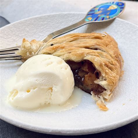 Thematic photo of a slice of strudel with nectarines and a scoop of vanilla ice cream