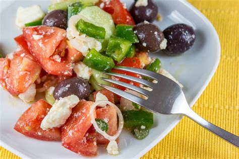 Fotografija pisane grške solate, pripravljene s svežo zelenjavo, olivami in sirom Feta.