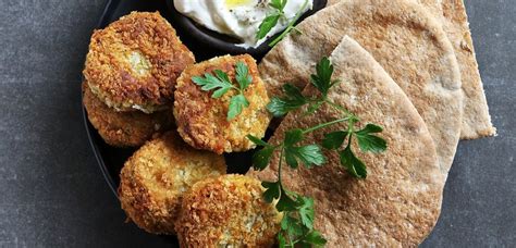 Fotografija falaflov z jogurtovo omako s tahinijem.