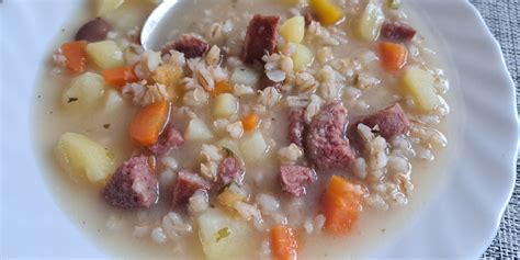 Prikaz kuhanega ričeta z ješprenjem, korenjem in krompirjem v skledi