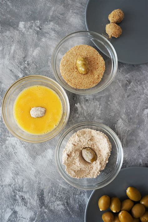 Pripravljene ocvrte polnjene olive na krožniku z omako aioli