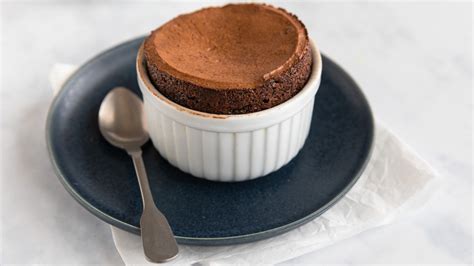 Temno čokoladni sufle v keramični posodici, posut s sladkorjem v prahu