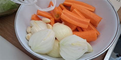 različne surove sestavine za juho: rdeča leča, čebula, korenje, zelena, česen, paradižnik, začimbe