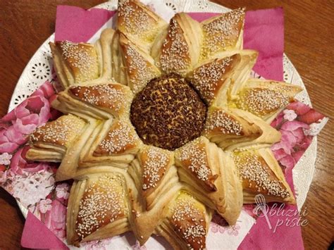 Pečena pogača sončnica na pekaču, zlato rjava in okrašena s semeni.