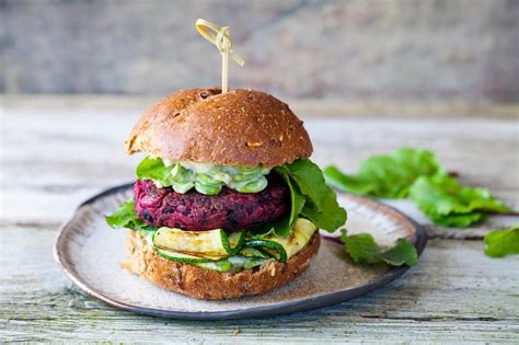 Tematska fotografija veganskih burgerjev iz rdeče pese z različnimi dodatki
