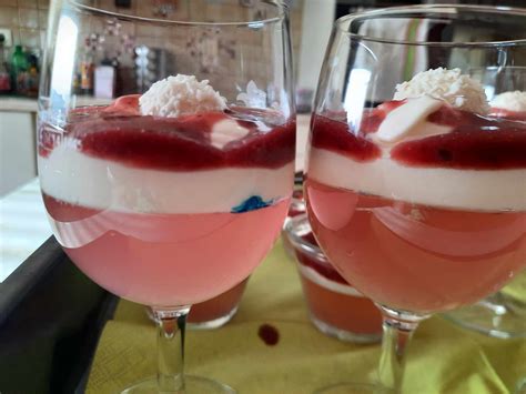 Slika zelenega smoothija v kozarcu s slamico, obdanega s svežim sadjem in zelenjavo.