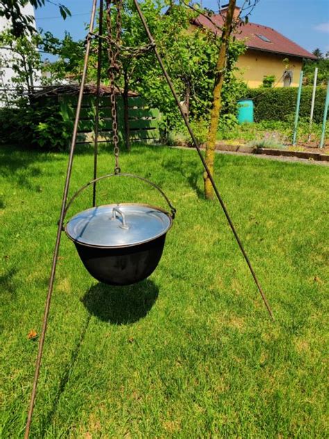 Prikaz različnih vrst kotlov in trinožnikov za kuhanje na odprtem ognju v naravi