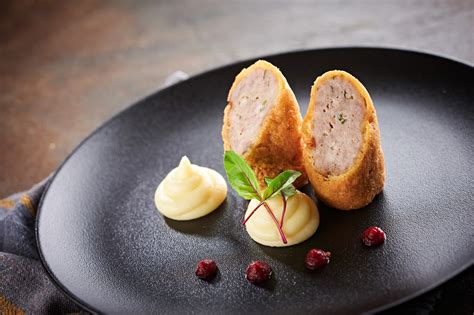 Prikaz korakov priprave dunajskega zrezka: potolčeno meso, paniranje v moki, jajcih in drobtinah, cvrtje v ponvi.