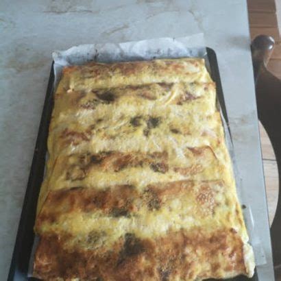 Sestavljene in prelite skutine palačinke v pekaču pred peko