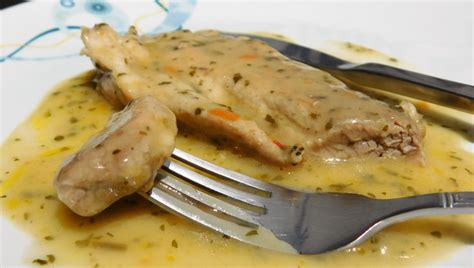 Svinjski zrezki v bogati česnovi omaki, postreženi s prilogo.