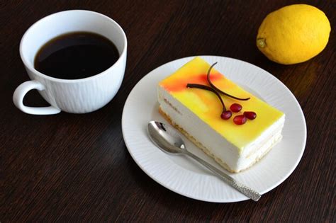 Thematic photo of a slice of lemon cake with a cup of coffee.