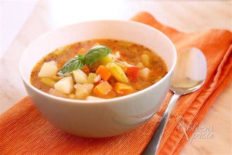 Pripravljena enolončnica s fižolom, korenjem in krompirjem, servirana v globokem krožniku.