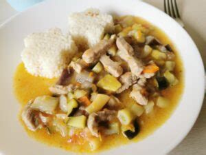 Pripravljeni svinjski trakci v bogati zelenjavni omaki s koruzo, pripravljeni za postrežbo.