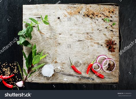 Thematic photo of various fresh herbs and spices on a wooden board, ready for cooking