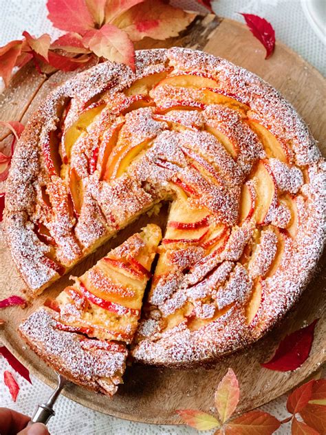 Jabolčni kolač, okrašen z jedilnimi cvetlicami.