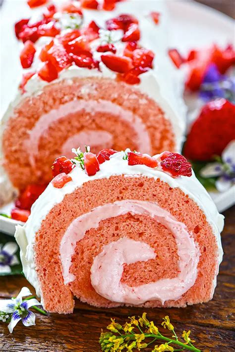 The final decorated strawberry roll cake slice on a plate, with a patterned biscuit exterior