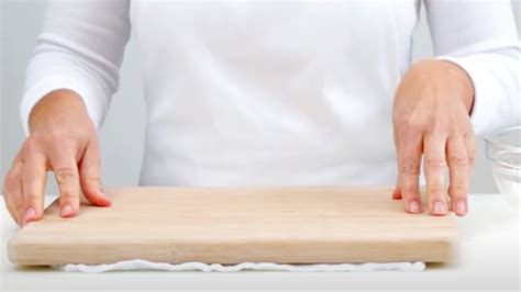Sequence of images showing how to roll a warm biscuit with a damp cloth