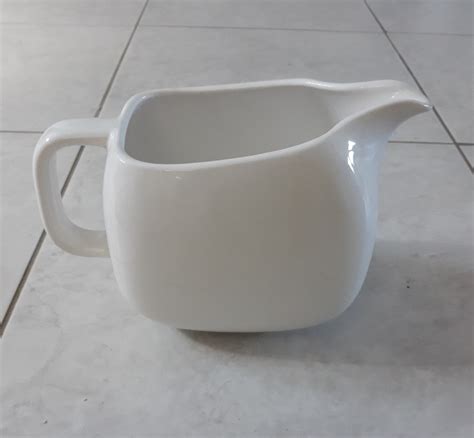 fotografija kuskusa, ki ga kuhar razrahlja z vilicami v beli keramični posodi