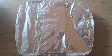 Slika počivajočega svinjskega zrezka, pokritega z alu folijo