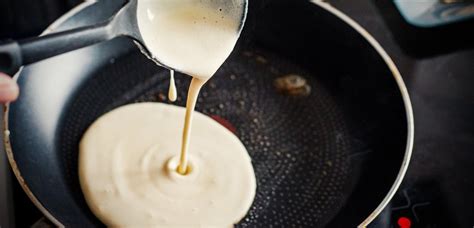 Fotografija pečenih skutinih palačink v pekaču, prelitih s smetano.