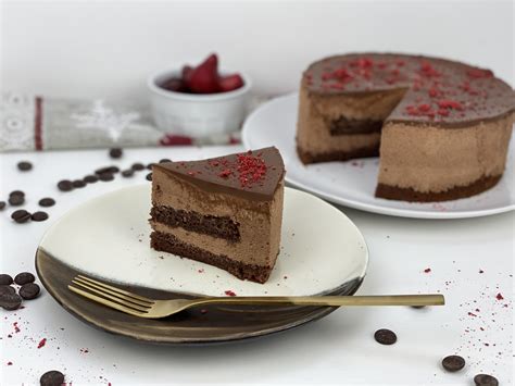 Sestavljena čokoladna torta z lešniki v tortnem obroču, pripravljena za hlajenje.