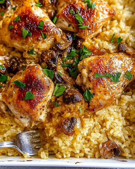 Oven-baked chicken and rice with bell pepper in a baking dish, covered with foil.