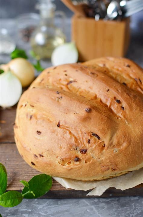 Thematic photo of a homemade onion bread on a rustic wooden board with a kitchen towel