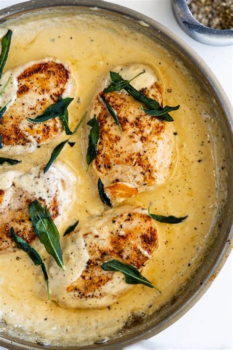 Thematic photo of chicken with peanuts, pineapple, and creamy cheese sauce, garnished with sage
