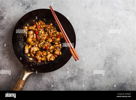 Thematic photo of stir-fried chicken with vegetables and peanuts in a wok