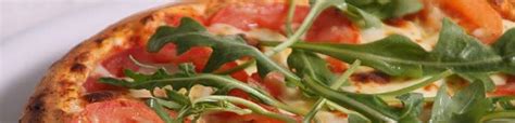 Fotografija velike pizze, ki se razprostira čez rob krožnika