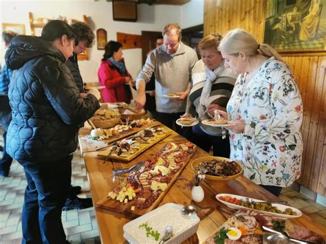 fotografija idilične slovenske turistične kmetije z mizo, polno tradicionalnih jedi