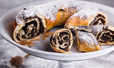 Prikaz postreženih kokosovih palačink z makovim nadevom, okusno okrošenih s stopljeno čokolado in kokosovo moko.