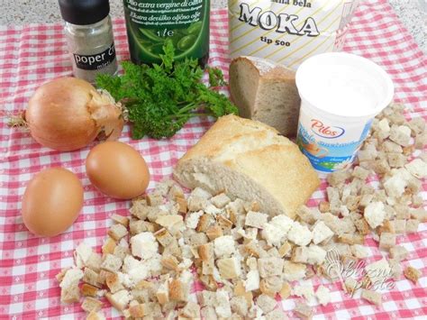 Prikaz sestavin za kruhove cmoke: kocke kruha, jajca, mleko, sveža zelišča in začimbe