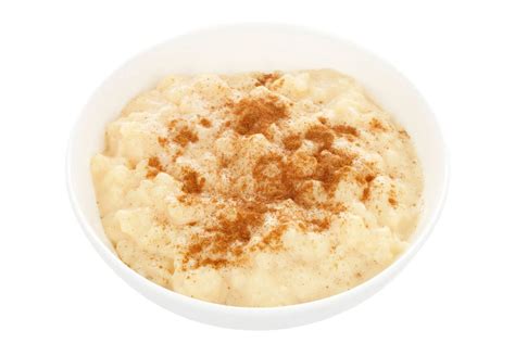 Mlečni riž v skodelici, posut s cimetom in svežim sadjem
