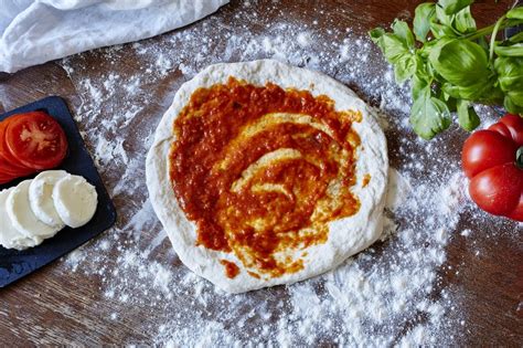 pripravljeno testo za pico na pomokani površini
