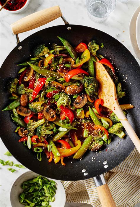 Thematic photo of a wok stir-frying colorful vegetables for noodles