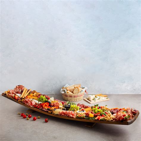 Različni narezani suhi pršuti in salame na deski